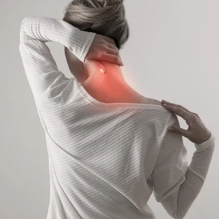 Individual with neck pain, touching the affected area highlighted in red, representing common conditions addressed by chiropractic care and spinal therapy.