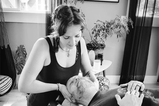 Dr. Emme Lyda DC performing a neck adjustment on a reclining patient.